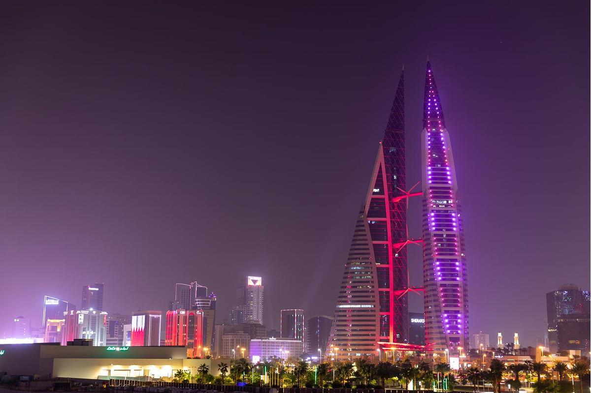 مباني العاصمة المنامة تتشح باللونين العنابي والأبيض احتفاءً بالعيد الوطني لدولة قطر 